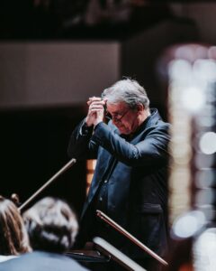 John Storgårds avec l'orchestre, les mains levées en signe de remerciement